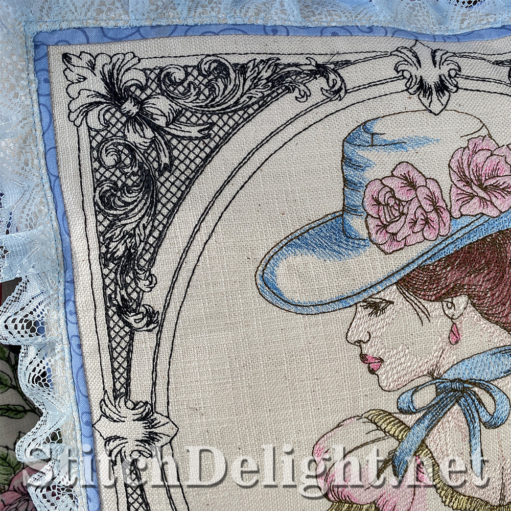 Embroidered design of a woman wearing a decorative hat with flowers, framed by lace and intricate patterns.