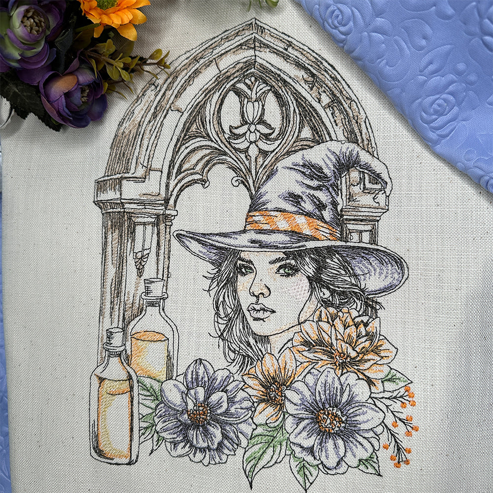 Embroidery design of a woman in a witch hat with flowers and bottles on fabric.